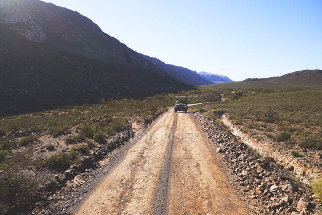 Safari off-road vehicle driving on sunny remote dirt road South Africa — Stock Photo