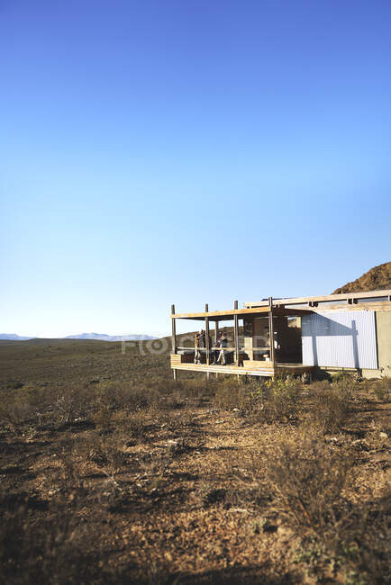 Amis sur le balcon de la cabane safari à distance ensoleillée Afrique du Sud — Photo de stock