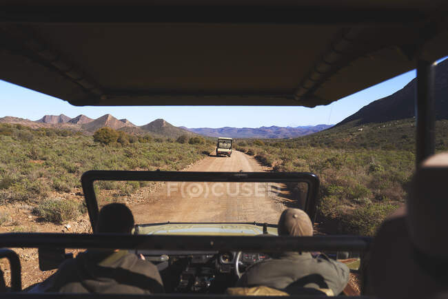 Safari tour guide drive off-road vehicle sunny dirt road South Africa — Stock Photo