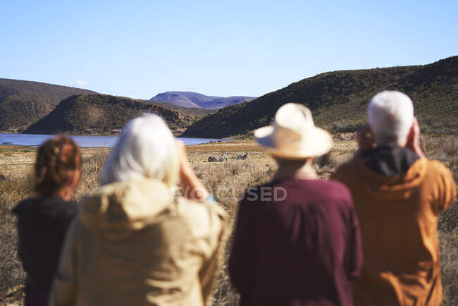 Senior friends on safari watching zebras in distance Sudafrica — Foto stock