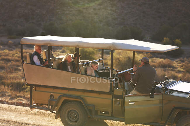 Safari guía turístico y grupo en vehículo todoterreno - foto de stock