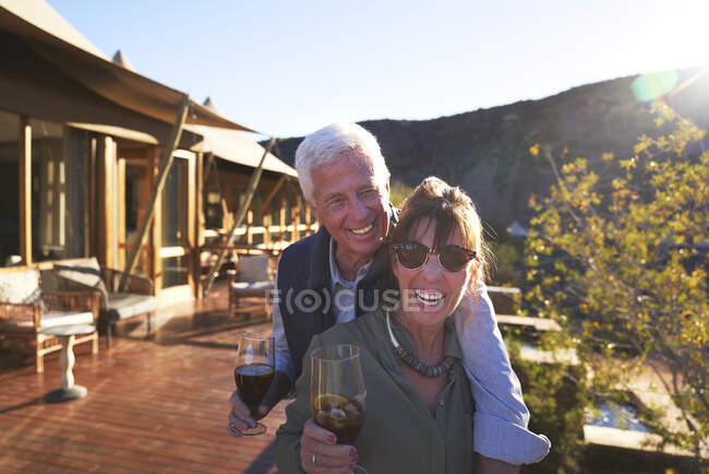 Ritratto felice coppia anziana bere tè freddo sul balcone soleggiato dell'hotel — Foto stock