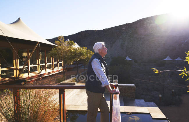 Sereno uomo anziano rilassante sul balcone soleggiato safari lodge — Foto stock