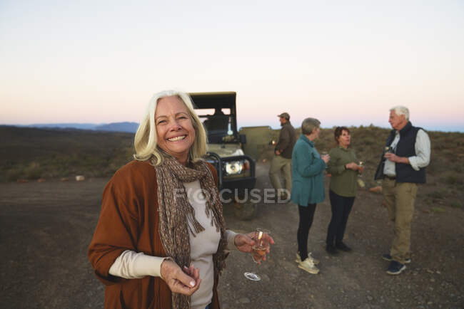 Retrato feliz sênior mulher bebendo champanhe no safari — Fotografia de Stock
