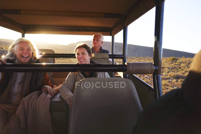 Happy friends riding in safari off-road vehicle — Stock Photo