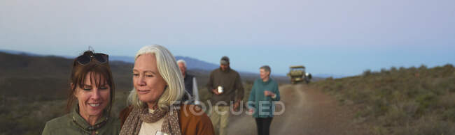 Щасливі жінки друзі на сафарі гуляють по ґрунтовій дорозі — стокове фото