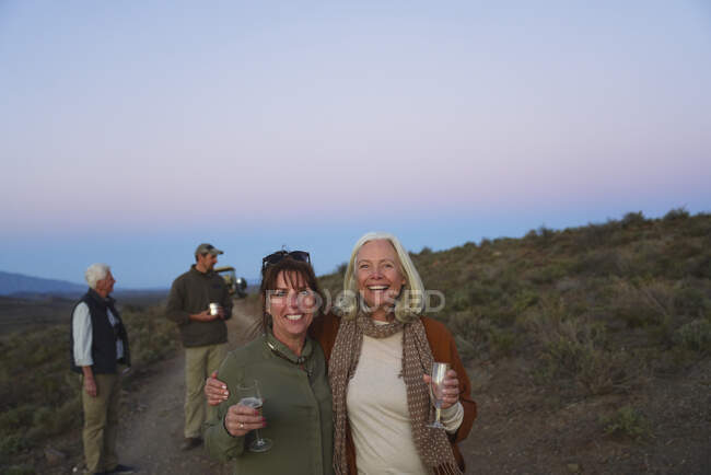 Ritratto felice donne mature amiche sul safari bere champagne — Foto stock