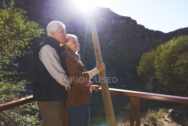 Feliz pareja de ancianos relajándose en el balcón soleado - foto de stock