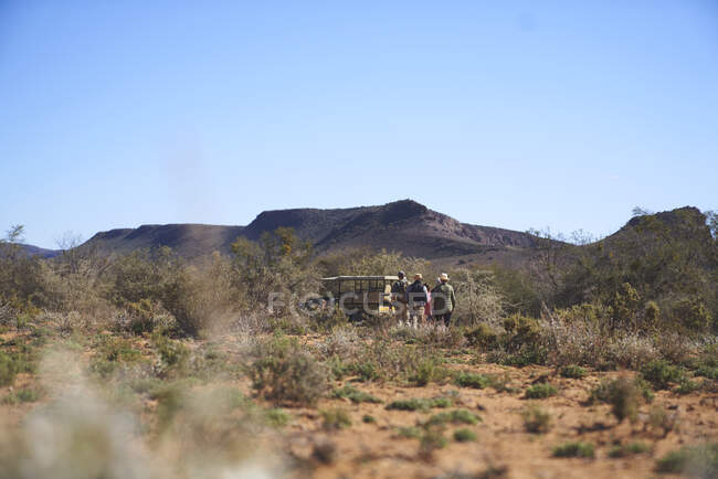 Safari groupe de randonnée à pied à véhicule hors route réserve animalière ensoleillée — Photo de stock