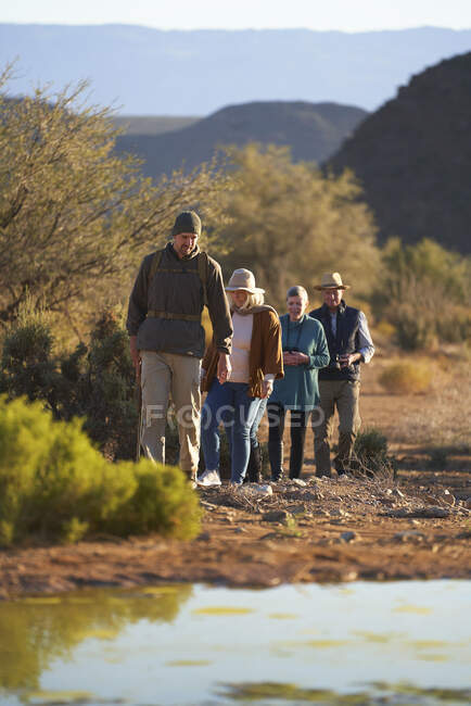 Safari-Reiseleiter führt Gruppe durch sonniges Naturschutzgebiet — Stockfoto