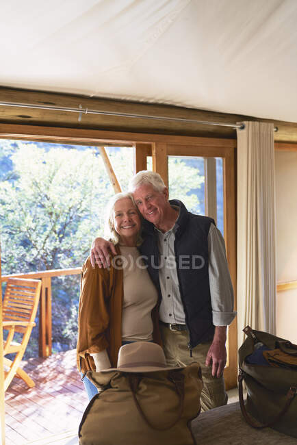 Ritratto felice coppia anziana che abbraccia in camera d'albergo — Foto stock