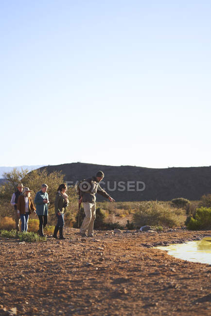 Safari tour guide leading group on sunny wildlife reserve South Africa — Stock Photo