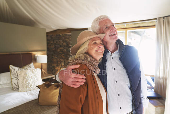 Unbekümmertes Senioren-Paar umarmt sich in Safari-Lodge-Hotelzimmer — Stockfoto