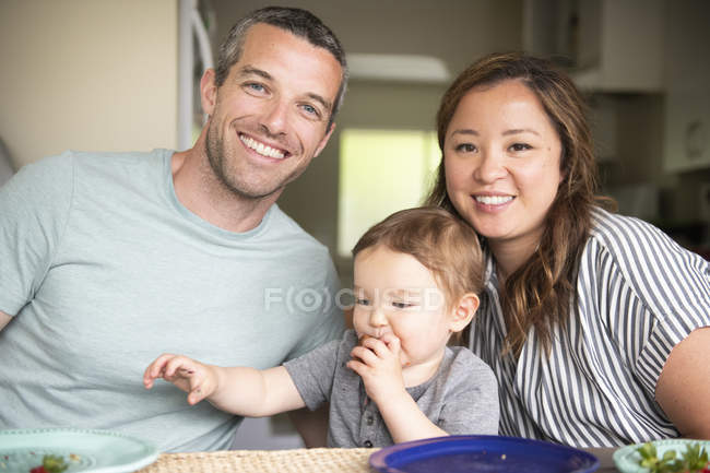 Retrato feliz familia joven comiendo - foto de stock