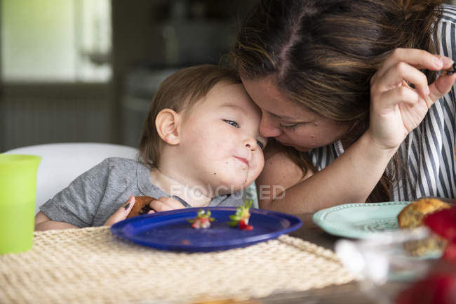 Close up affectionate mother and toddler daughter eating — Stock Photo