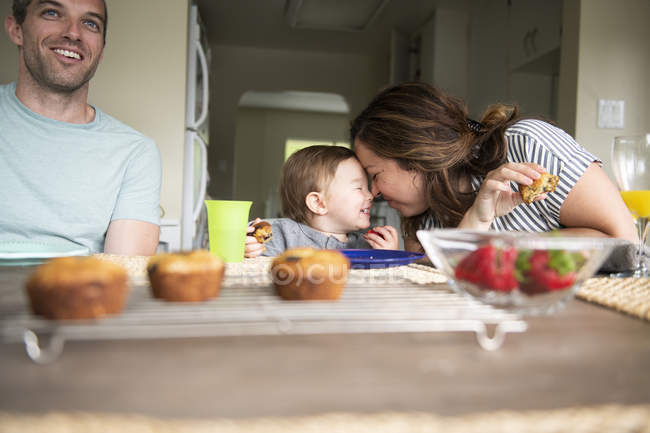 Щаслива мати і дочка терти носи за кухонним столом — стокове фото