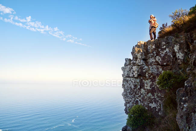 Couple étreignant sur une falaise au-dessus de l'océan ensoleillé Cape Town Afrique du Sud — Photo de stock