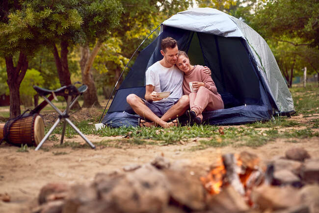 Glückliches Liebespaar entspannt sich im Zelt auf dem Campingplatz — Stockfoto