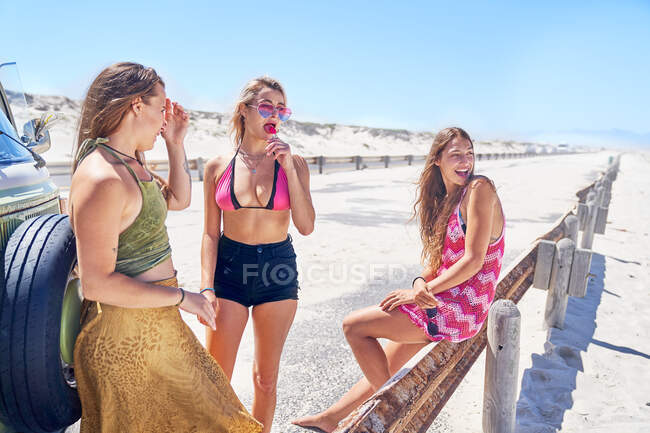 Young women friends relaxing at sunny summer beach — Stock Photo