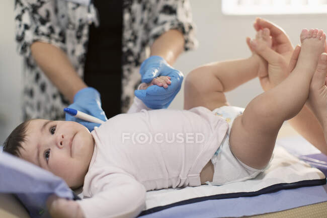 Cute baby girl laying examination room table — Stock Photo