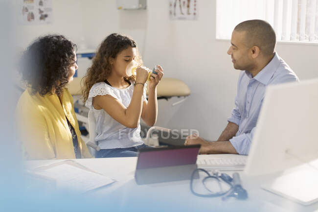 Pediatra masculino ensinando paciente menina como usar inalador no consultório médico — Fotografia de Stock