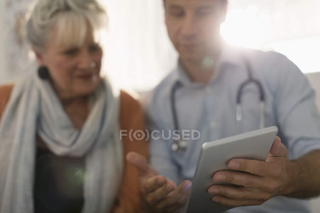 Чоловік лікар показує цифровий планшет пацієнту — стокове фото