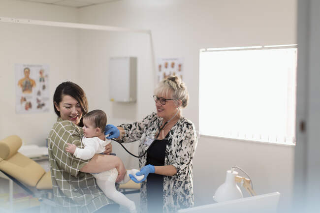 Pediatra feminina examinando bebê na sala de exame — Fotografia de Stock
