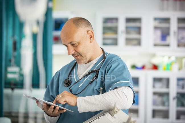 Чоловік лікар використовує цифровий планшет в лікарні — стокове фото