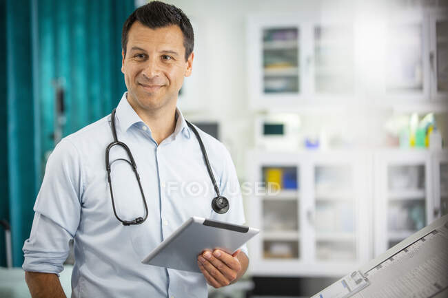 Retrato médico masculino confiante com tablet digital no hospital — Fotografia de Stock