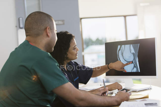 Медсестры обсуждают цифровой рентген на компьютере в клинике — стоковое фото