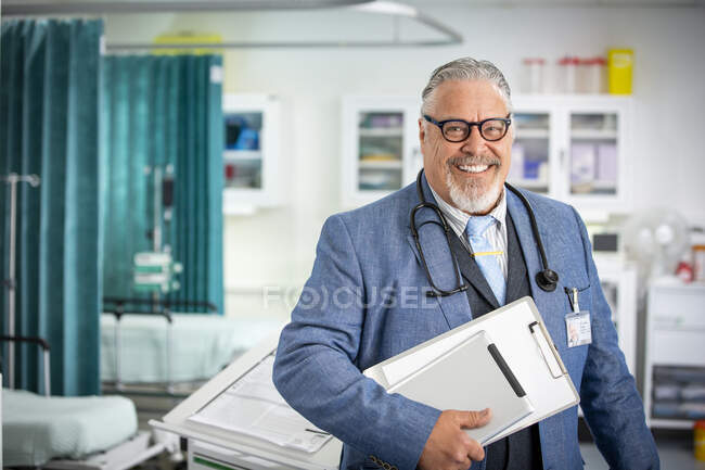 Portrait médecin senior homme confiant faisant des rondes à l'hôpital — Photo de stock