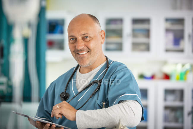 Портрет впевненого лікаря-чоловіка з цифровим планшетом у лікарні — стокове фото