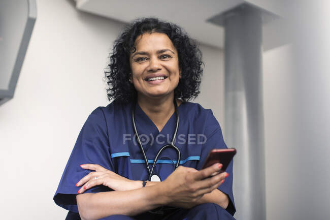 Retrato médico feminino confiante usando telefone inteligente — Fotografia de Stock