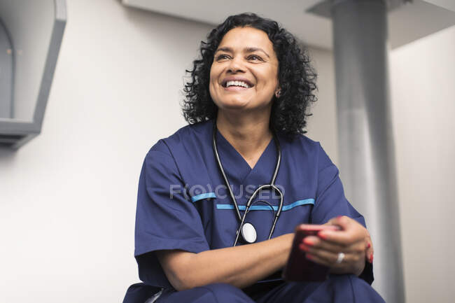 Портрет усміхнений, щаслива жінка-лікар використовує смартфон — стокове фото