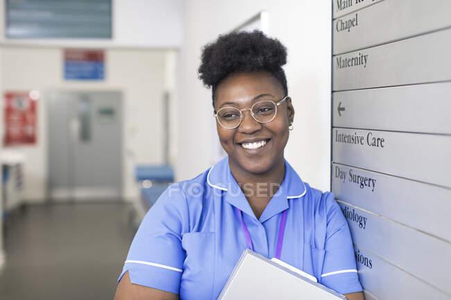Портрет улыбается, уверенная в себе медсестра в коридоре больницы — стоковое фото