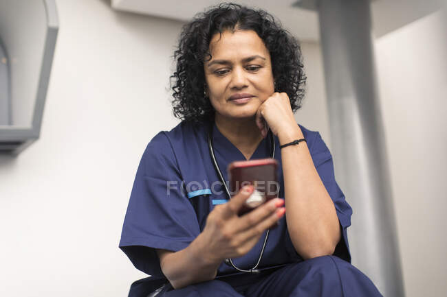 Жінка-лікар за допомогою смартфона — стокове фото