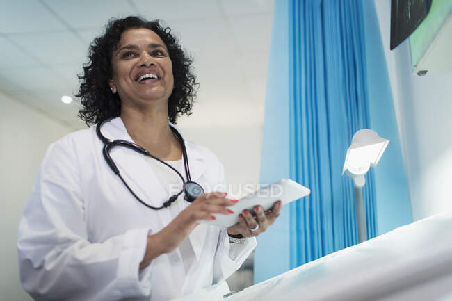 Joyeuse femme médecin avec tablette numérique à l'hôpital — Photo de stock