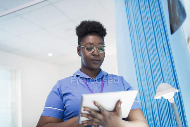 Female nurse using digital tablet in hospital room — Stock Photo