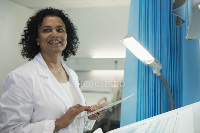 Улыбающаяся женщина-врач с помощью цифрового планшета в больничной палате — стоковое фото