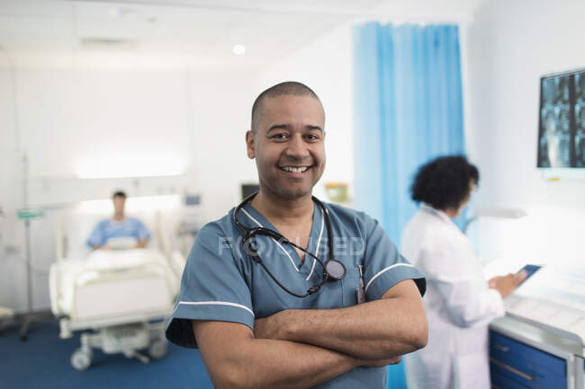 Портрет впевнений, усміхнений чоловік медсестра в лікарняній кімнаті — стокове фото