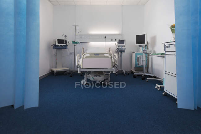 Habitación de hospital vacía con cama y equipo médico - foto de stock
