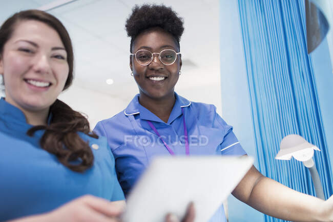 Retrato confiado médico y enfermera utilizando tableta digital en la habitación del hospital - foto de stock
