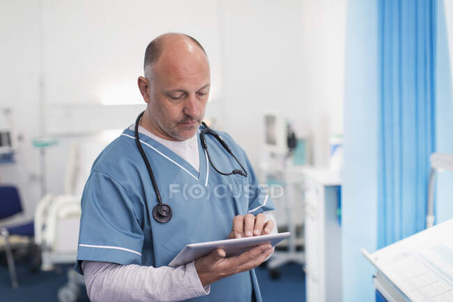 Médico masculino usando tablet digital no quarto do hospital — Fotografia de Stock