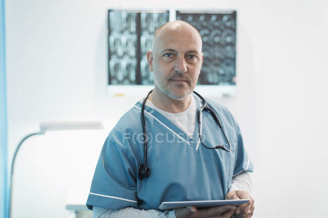 Портрет впевненого лікаря-чоловіка, який використовує цифровий планшет у лікарні — стокове фото