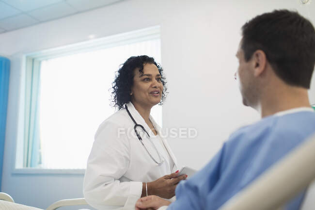 Лікар робить обхід і розмовляє з пацієнтом у лікарняній палаті. — стокове фото