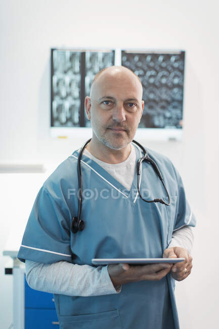 Портрет уверенный мужчина врач с помощью цифрового планшета в больнице — стоковое фото