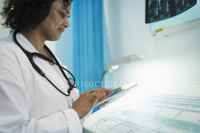 Doctora usando tableta digital en la habitación del hospital - foto de stock
