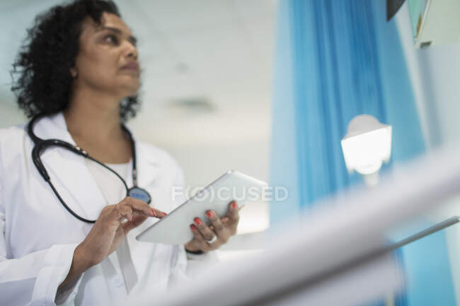 Médecin femelle ciblée utilisant une tablette numérique dans la chambre d'hôpital — Photo de stock