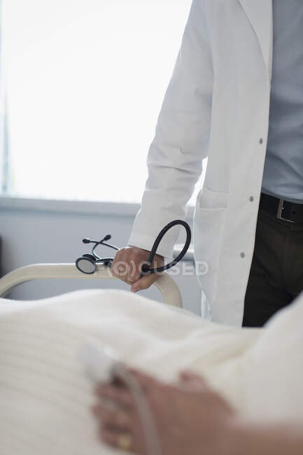 Médico com estetoscópio fazendo rondas no quarto do hospital — Fotografia de Stock
