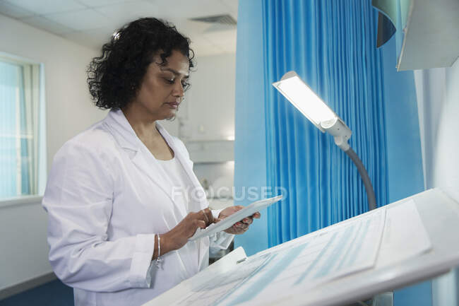 Женщина-врач с помощью цифрового планшета в больничной палате — стоковое фото